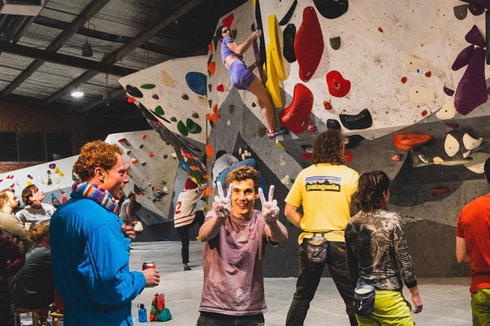 A person holding up the peace symbol at some of the best rock climbing Melbourne has to offer.